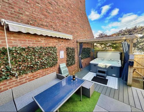 a backyard with a barbecue and a brick building at Private All-Weather Hot Tub Apartment, Free Parking, 1 Mile to City Centre, Cafés & Dining Nearby in Jesmond