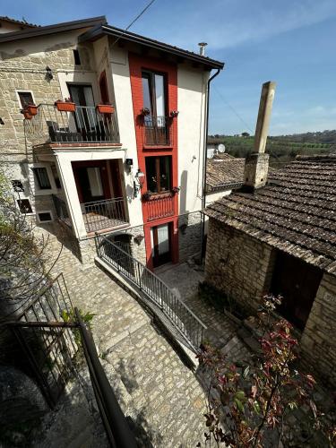 an old house with red doors and balconies on a street at Dimora Forgione B&B - Pietrelcina in Pietrelcina