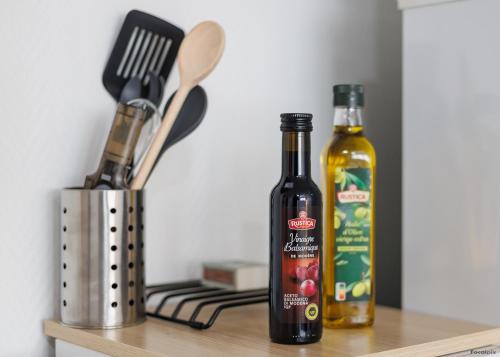 two bottles of alcohol sitting on a kitchen shelf at LE COCON - T1 - 26 m2 in Lhommaizé