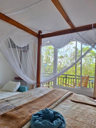 a bedroom with a bed and a large window at Lilly Guest Inn in Haputale