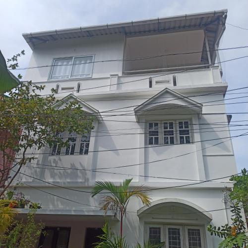 a white building with windows and power lines at Bethesda Inn in Cochin
