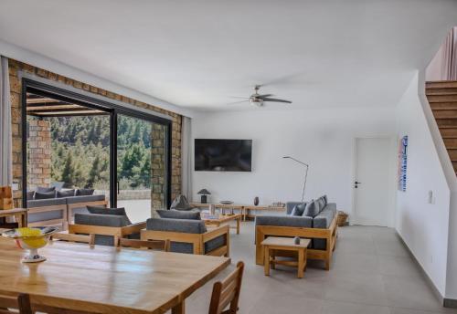 a living room with wooden furniture and a large window at The Mavrolitharo Residence in Akti Salonikiou