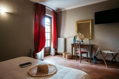 a bedroom with a bed with a hat on it at Agriturismo Tenuta La Romana in Nizza Monferrato