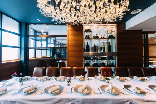 a long table in a restaurant with a chandelier at The Club Hotel & Spa Jersey in Saint Helier Jersey