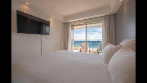 une chambre avec un grand lit avec vue sur l'océan dans l'établissement Magnifique appartement vue panoramique - Croisette, à Cannes