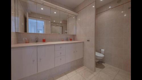 une salle de bain avec deux lavabos et un WC et un miroir dans l'établissement Magnifique appartement vue panoramique - Croisette, à Cannes