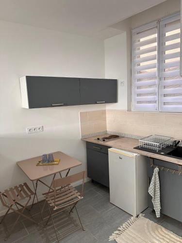 une cuisine avec une table et une cuisinière four supérieur dans l'établissement Studio charmant Cocon des Poètes non fumeur quartier Victor Hugo centre ville, à Béziers