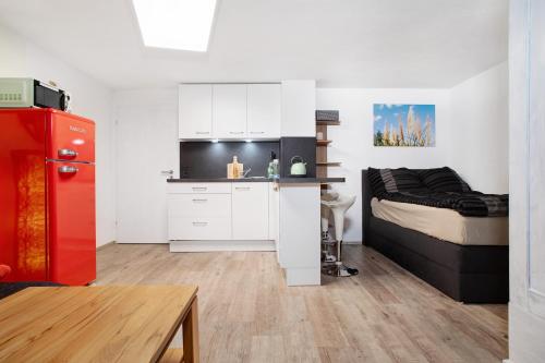 a kitchen with a red refrigerator next to a bed at Carpe Diem in Altshausen