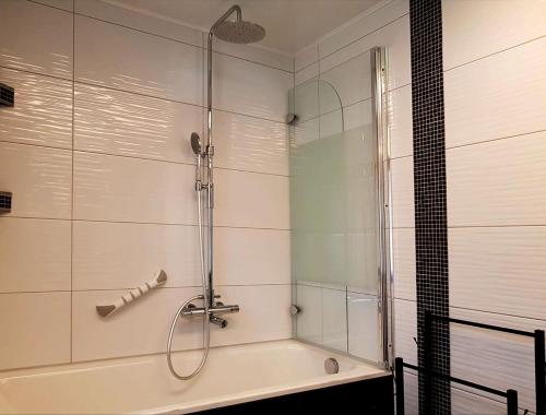 a bathroom with a shower and a bath tub at Ferienhaus TraunseeStrand in Ebensee
