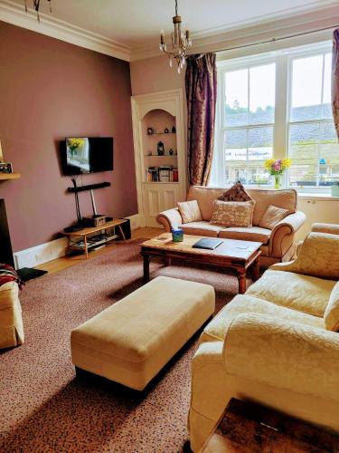 a living room with a couch and a table at Huge 4 Bed Apt - Perfect Base to Explore The Borders in Jedburgh