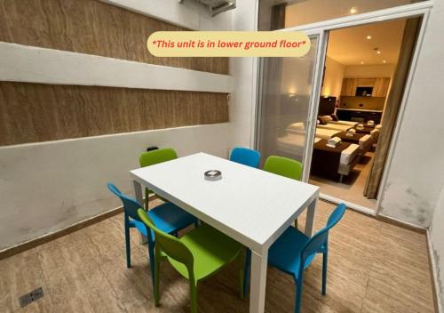 a dining room with a white table and blue chairs at Bayside A Apartments in St Julian's