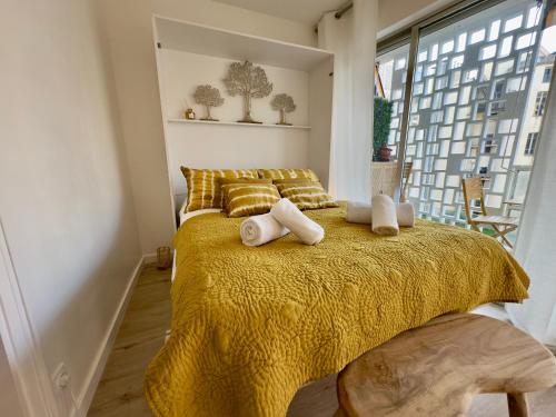 - une chambre avec un lit jaune, des oreillers et une fenêtre dans l'établissement L'Éclat Safran - Royal Luxembourg, à Nice