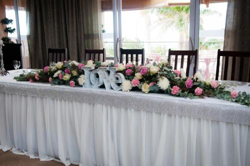 a long table with flowers on top of it at Umthunzi Hotel and Conference in Umtentweni