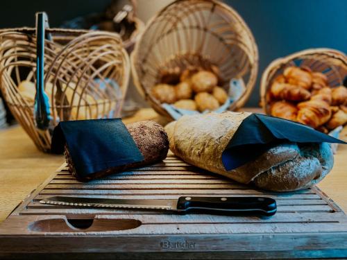 a table with bread and baskets and a knife at Hotel De Zeeuwse Stromen in Renesse