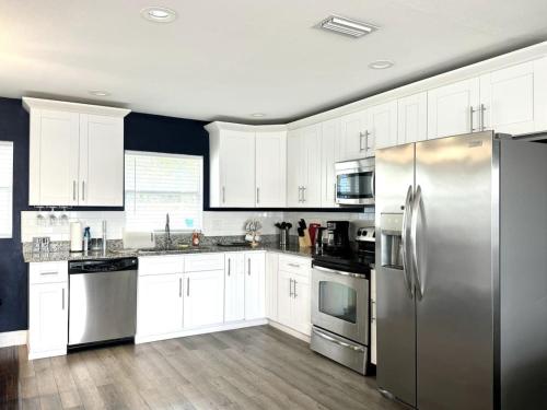 a kitchen with white cabinets and a stainless steel refrigerator at Home in Clearwater Quiet Spacious close to beaches in Largo