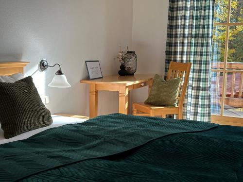 a bedroom with a bed and a desk and a window at Zwieslerwaldhaus4 in Lindberg