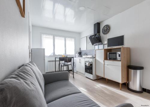 a living room with a couch and a kitchen at LE REPAIRE - T2 23 m2 in Lhommaizé