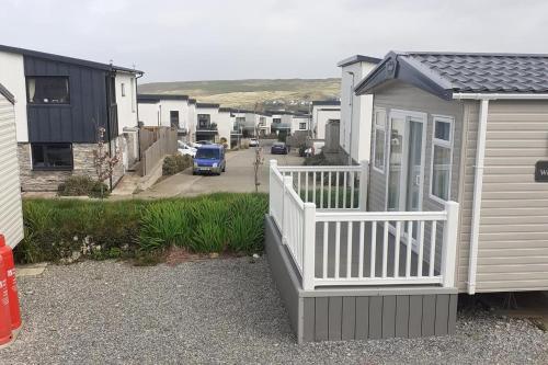 a small house with a white porch and a driveway at PerranporthCaravan 2bedroom Tv GasFire in Perranporth