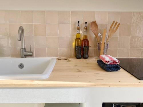 a kitchen counter with a sink and utensils at Le Joyeux - T3 au coeur du Quartier Haut in Sète