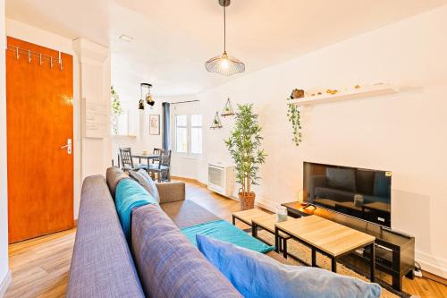 un salon avec un canapé bleu et une télévision dans l'établissement T2 Cathédrale & Torre Ventosa - Central - Clim - Wifi - Balcon - Free parking sur demande, à Béziers