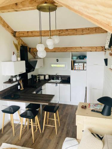 une cuisine avec des armoires blanches et une table et des chaises dans l'établissement Duplex en altitude, appartement au calme, aux Angles