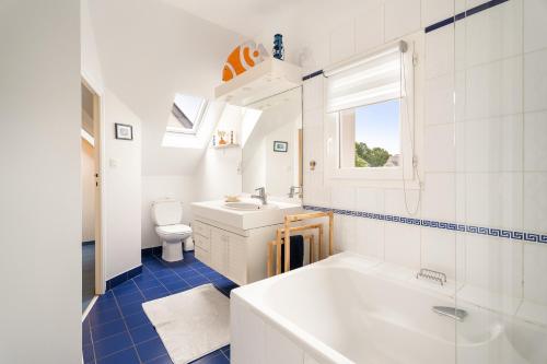 Un baño con bañera, lavabo e inodoro. en L'escale du bord de Rance, en La Richardais
