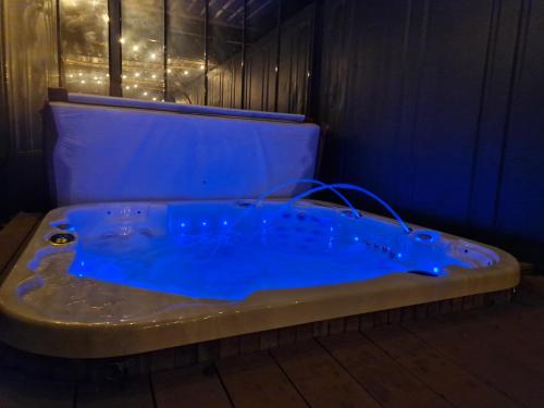 jacuzzi en una habitación con iluminación azul en Gîte le talus, en Amanlis