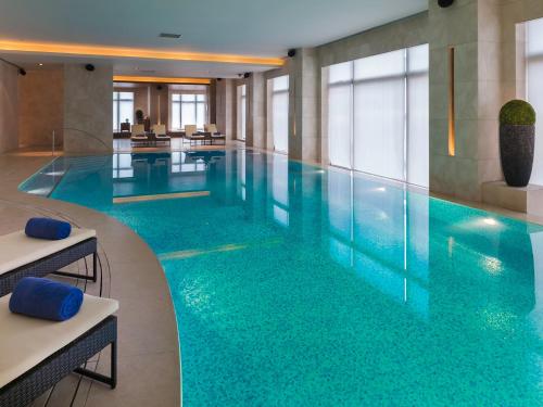 - une grande piscine d'eau bleue dans un bâtiment dans l'établissement Marco Polo Wuhan, à Wuhan