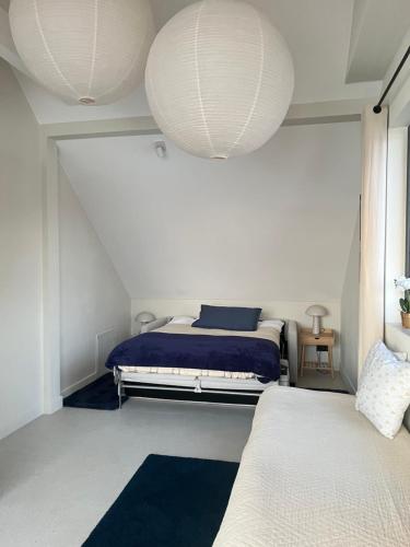 a bedroom with two beds and two lights at Pokój z widokiem na jezioro in Pluski