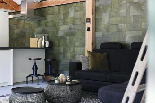 Una sala de estar con un sofá y dos mesas. en Luxury of Nature - boutique, en Helvoirt