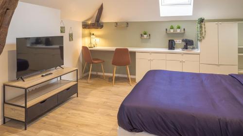 Cet appartement comprend une chambre avec un lit, une télévision et une cuisine. dans l'établissement Studio Danton - Sainte-Savine - 2 pers, à Sainte-Savine