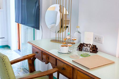 a dressing table with a mirror and a cup of coffee at Hotel Belair in Sorrento