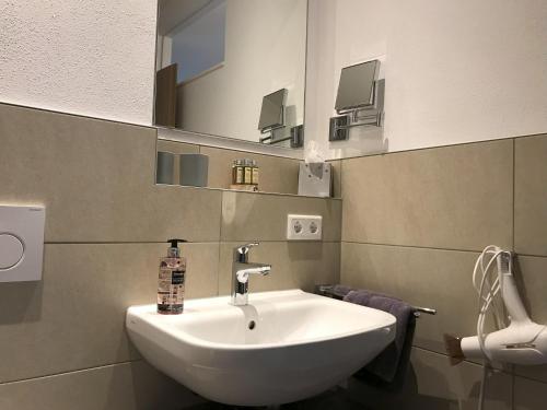 a white sink in a bathroom with a mirror at Appartementhaus Angelika in Nittenau
