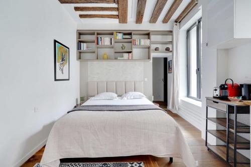 une chambre avec un grand lit dans une pièce blanche dans l'établissement Classy studio - Marais Bastille, à Paris