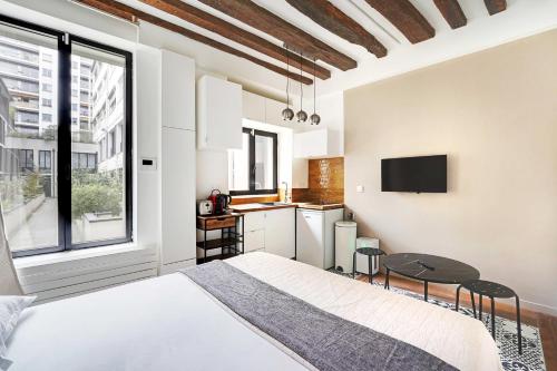 une chambre avec un lit et une petite cuisine dans l'établissement Classy studio - Marais Bastille, à Paris