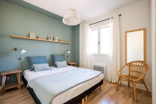 une chambre avec un grand lit et une chaise dans l'établissement Villa Bruyère à deux pas de la plage PYLA SUR MER, à La Teste-de-Buch