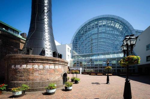 a building with a tower in the middle of a courtyard at 503好立地で札幌駅徒歩7分と大通駅徒歩6分で都心を満喫でき綺麗な部屋で快適が生活が実現 in Sapporo