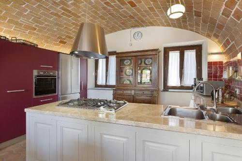 a kitchen with a sink and a stove top oven at Villa Teresa - Enticing villa with pool and views! in Gabiano