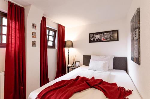 a bedroom with red curtains and a white bed at Der Thomataler Wirt in Thomatal