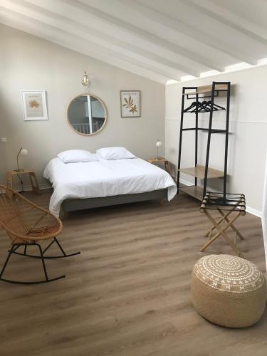 une chambre avec un lit, une chaise et un miroir dans l'établissement Duplex LOUIS, à Horbourg-Wihr
