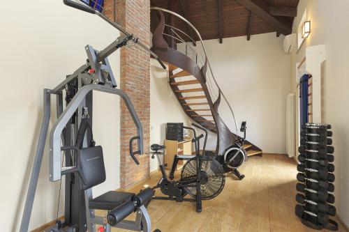 a gym with a bike and a spiral staircase at Villa Teresa - Enticing villa with pool and views! in Gabiano