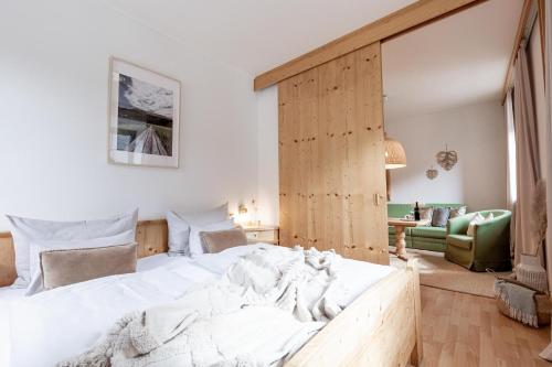 a bedroom with a large white bed with a wooden wall at Der Thomataler Wirt in Thomatal