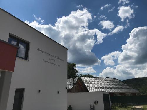a white building with clouds in the sky at Appartementhaus Angelika in Nittenau