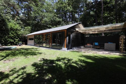 a black house with a large yard with a grass field at Luxury of Nature - boutique in Helvoirt