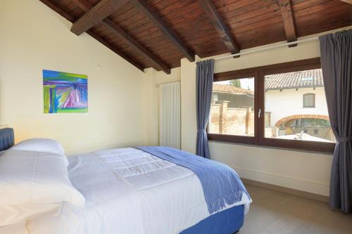 a bedroom with a bed and a large window at Villa Teresa - Enticing villa with pool and views! in Gabiano