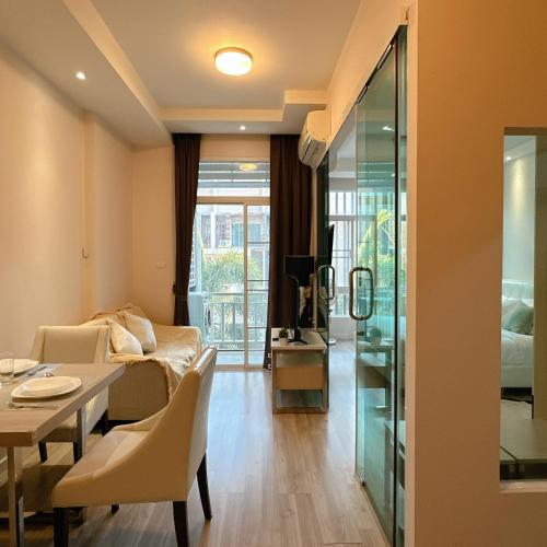 a living room with a dining table and a bedroom at Stylish room Near Central Fest in Chiang Mai