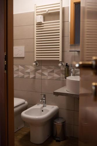 Un baño con lavabo, inodoro y espejo. en Lux of the Vatican, en Roma