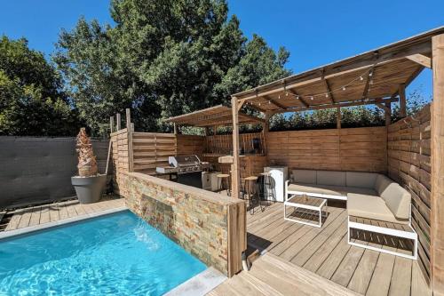 une cour arrière avec une piscine et une terrasse en bois dans l'établissement La Salanque Villa Standing Piscine chauffée, à Villelongue-de-la-Salanque