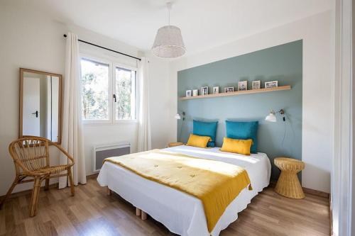 - une chambre dotée d'un grand lit avec des oreillers jaunes et bleus dans l'établissement Villa Arbousière à deux pas de la plage PYLA SUR MER, à La Teste-de-Buch