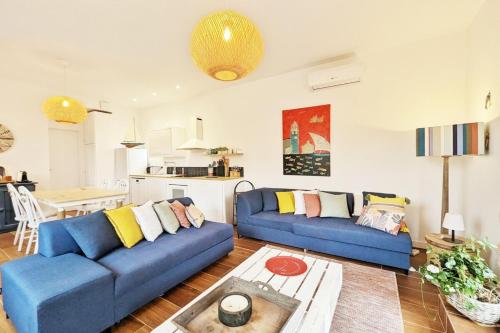 un salon avec deux canapés bleus et une cuisine dans l'établissement Casa Albera N1 des Villages préférés des Français, à Collioure